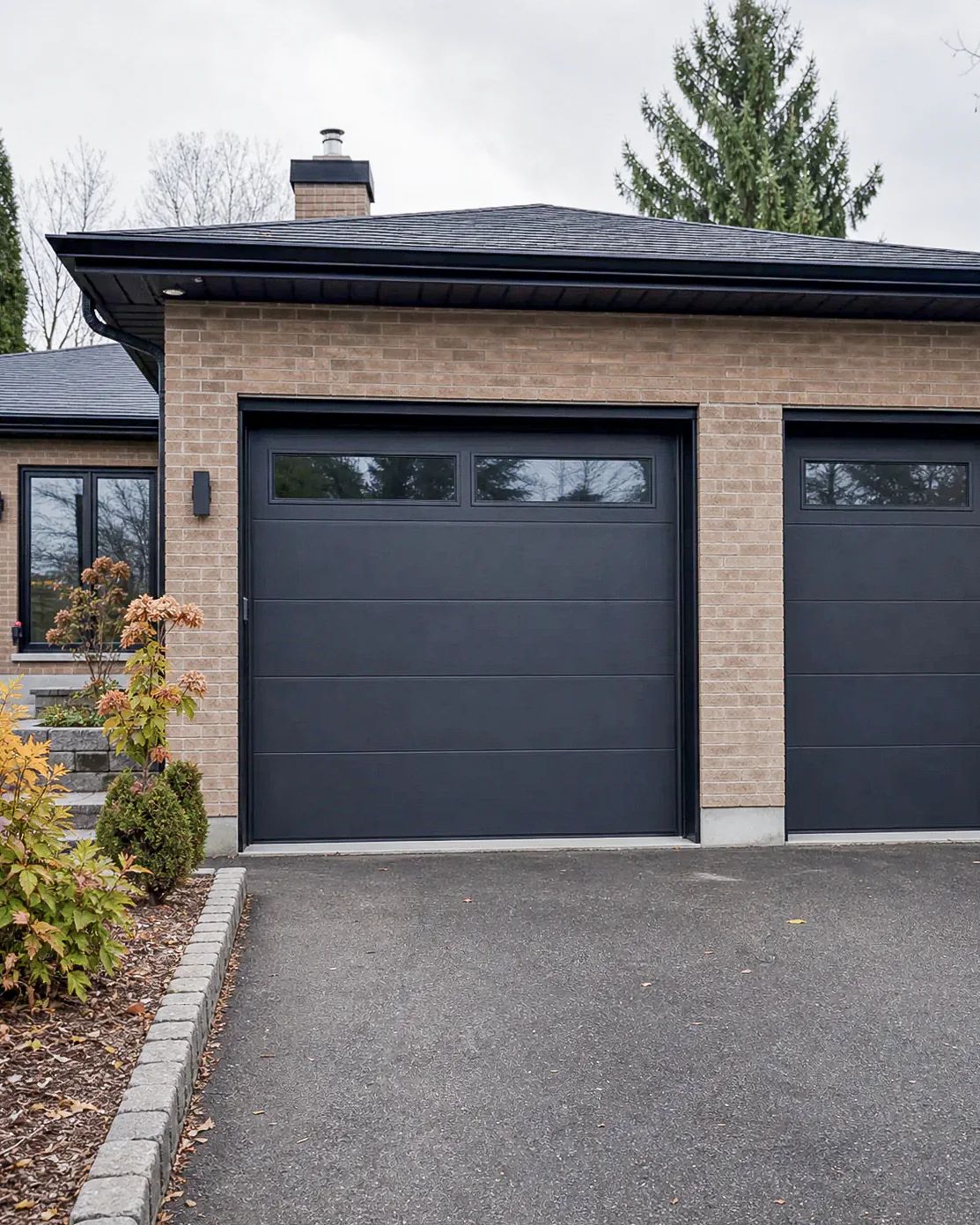 Maison fictive en brique avec portes de garage noires, image d’inspiration